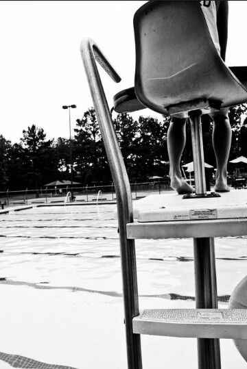 lifeguard sitting in a guard chair watching the pool