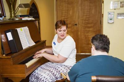 Music Therapist playing piano with resident.jpg