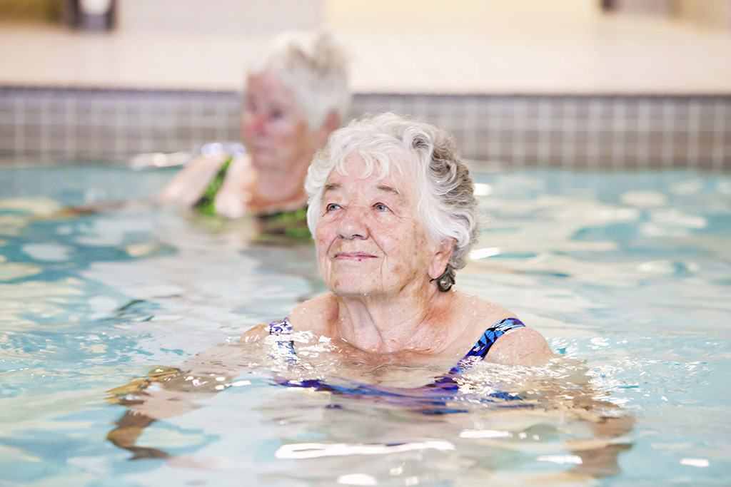 Happy resident smiling while in the pool for a resident swim