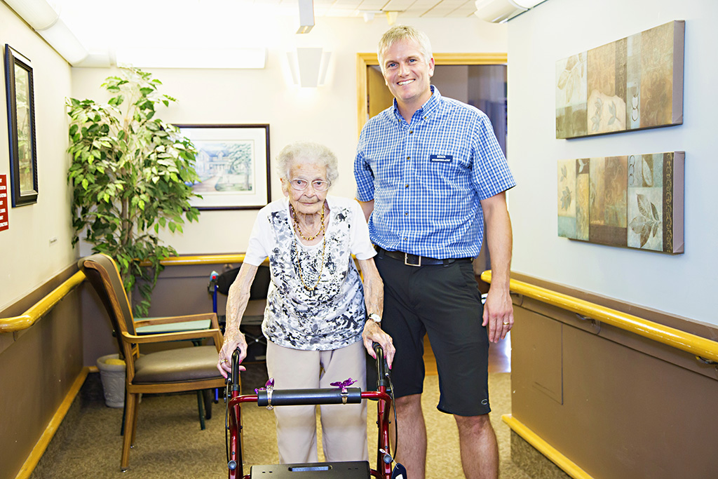 Physiotherapist walking with a female resident 