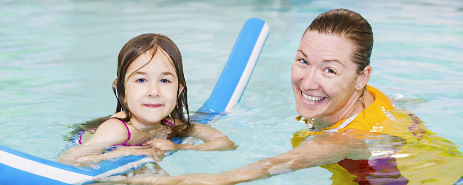 Child swimming with pool coordinator